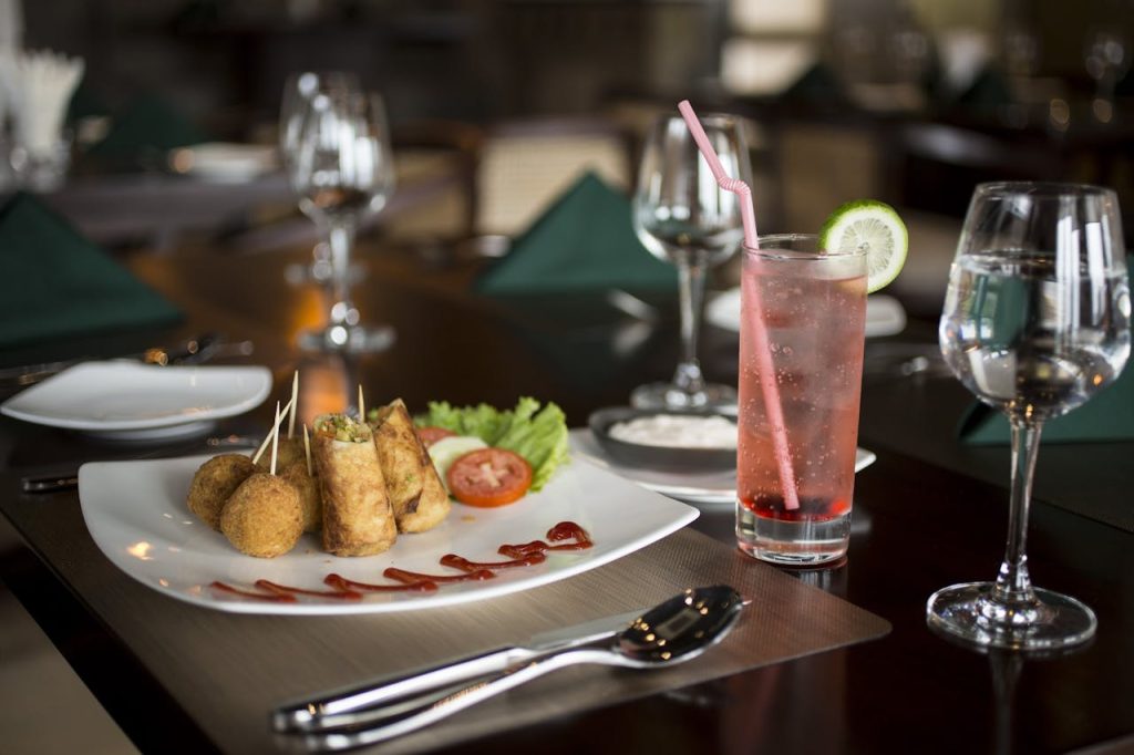 Delicious plated meal with savory snacks and a refreshing drink at a fine dining restaurant.